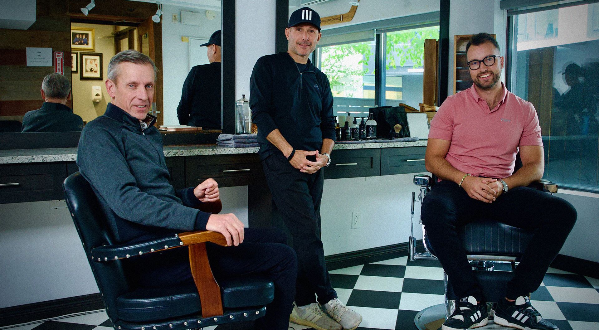 Three men sitting in a barbershop 