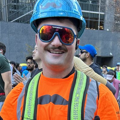 Construction worker with a Movember-branded shirt, smiling to camera.