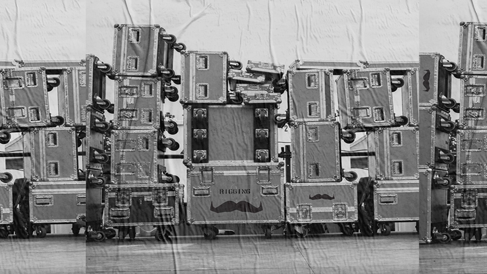 Black and white mural poster showing stacked PA gear road cases.