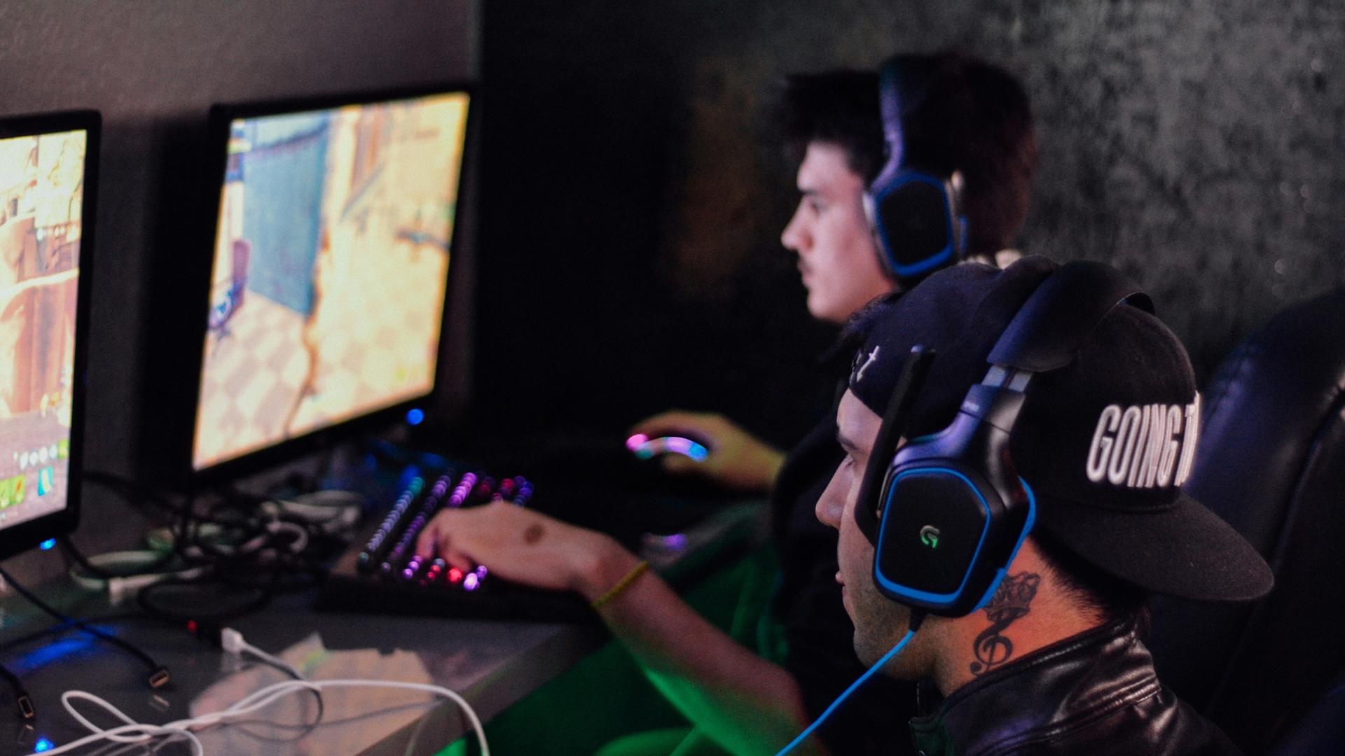 A group of young men laughing while gaming with headsets in. 