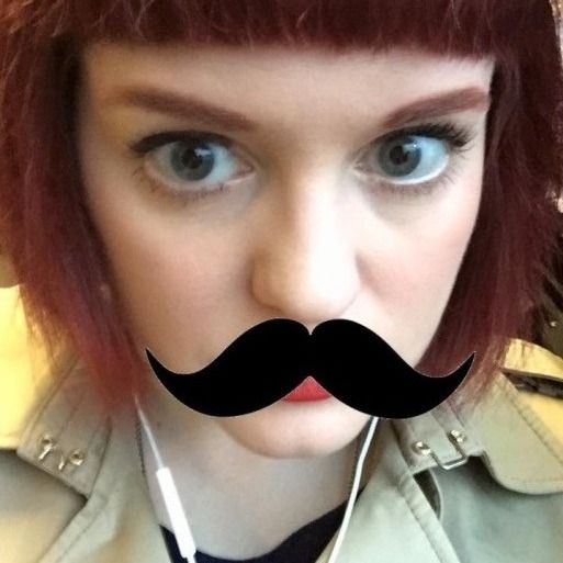 Photo of young woman, looking to camera. A digital filter showing a moustache is superimposed.