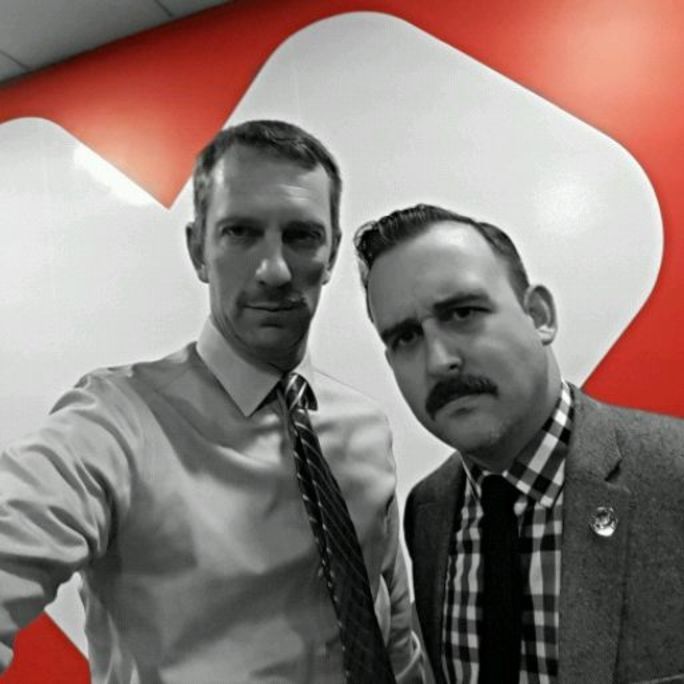 Photo of two men wearing shirts and ties, donning excellent moustaches and looking to camera.