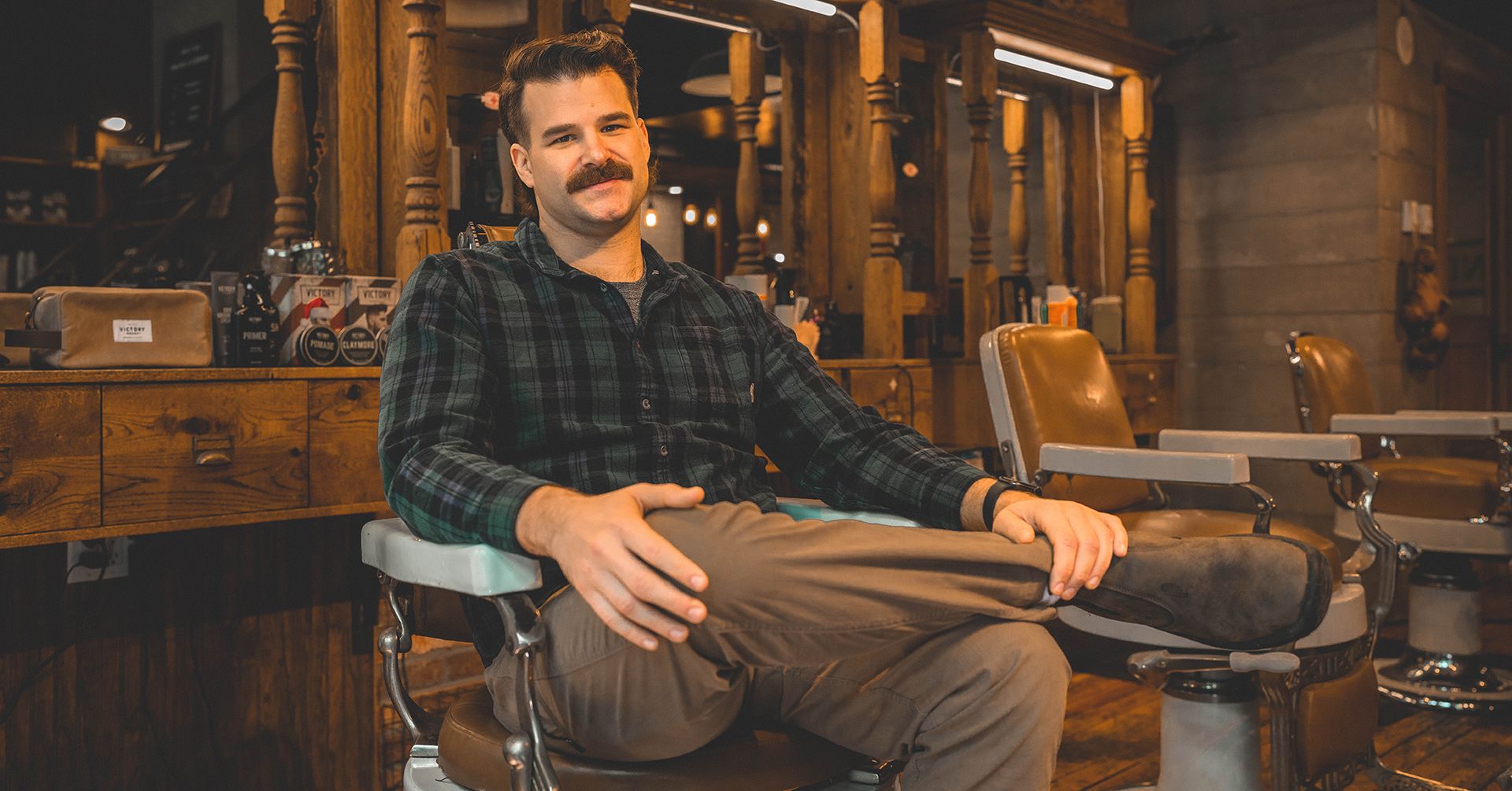 Moustachioed man sits in a barbershop in Vancouver