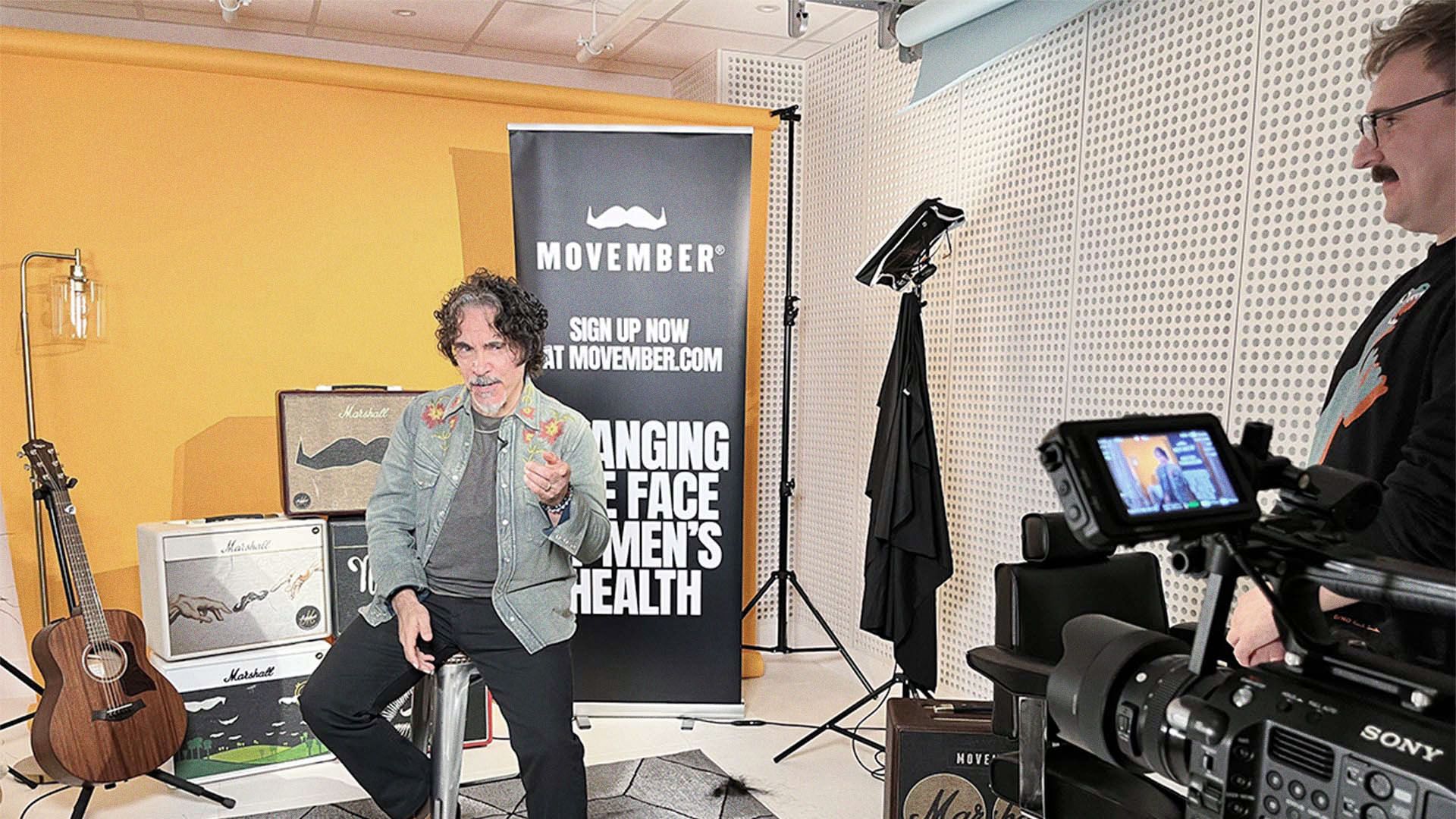 Photo of John Oates from Hall & Oates, recording video in a studio with a Movember staff member.