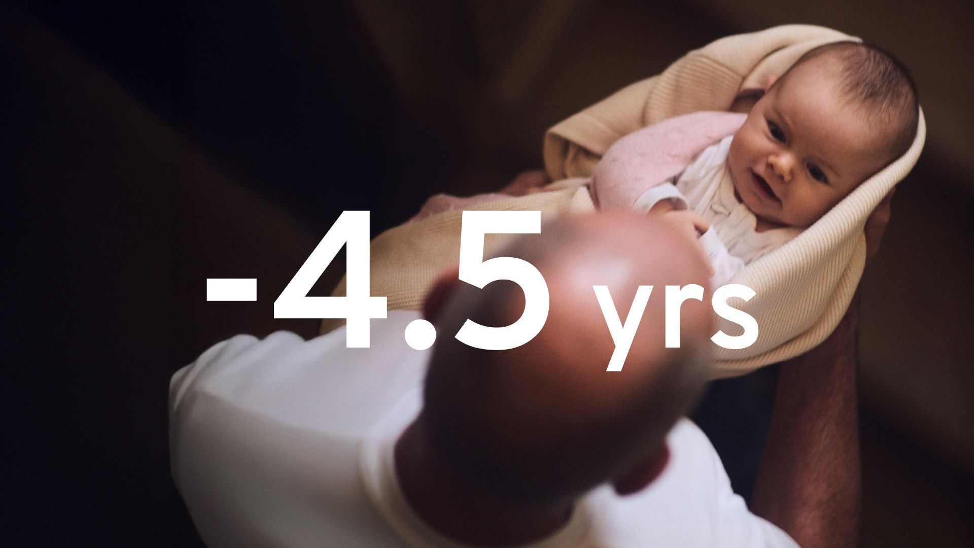 Dramatic image showing an infant, lovingly held by an elderly male relative. The words 4.5 years are superimposed in large white text.