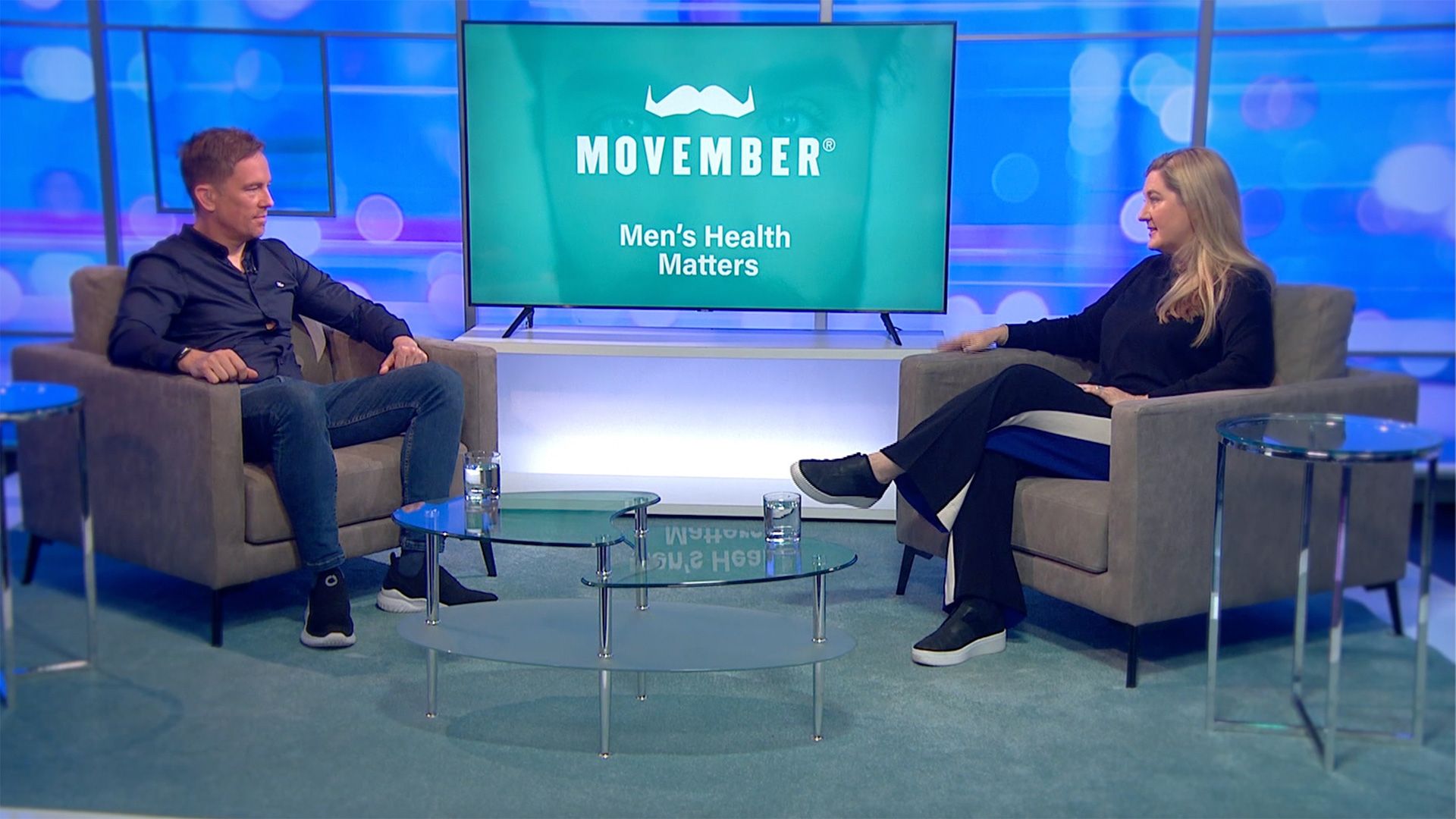 Two TV panellists sitting in couches, discussing men's health.