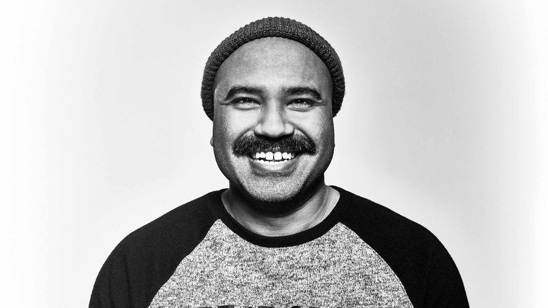 Man with moustache smiling to camera.
