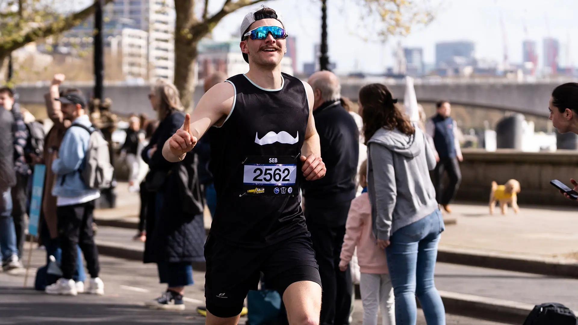 Runner with a Movember tank top running outside