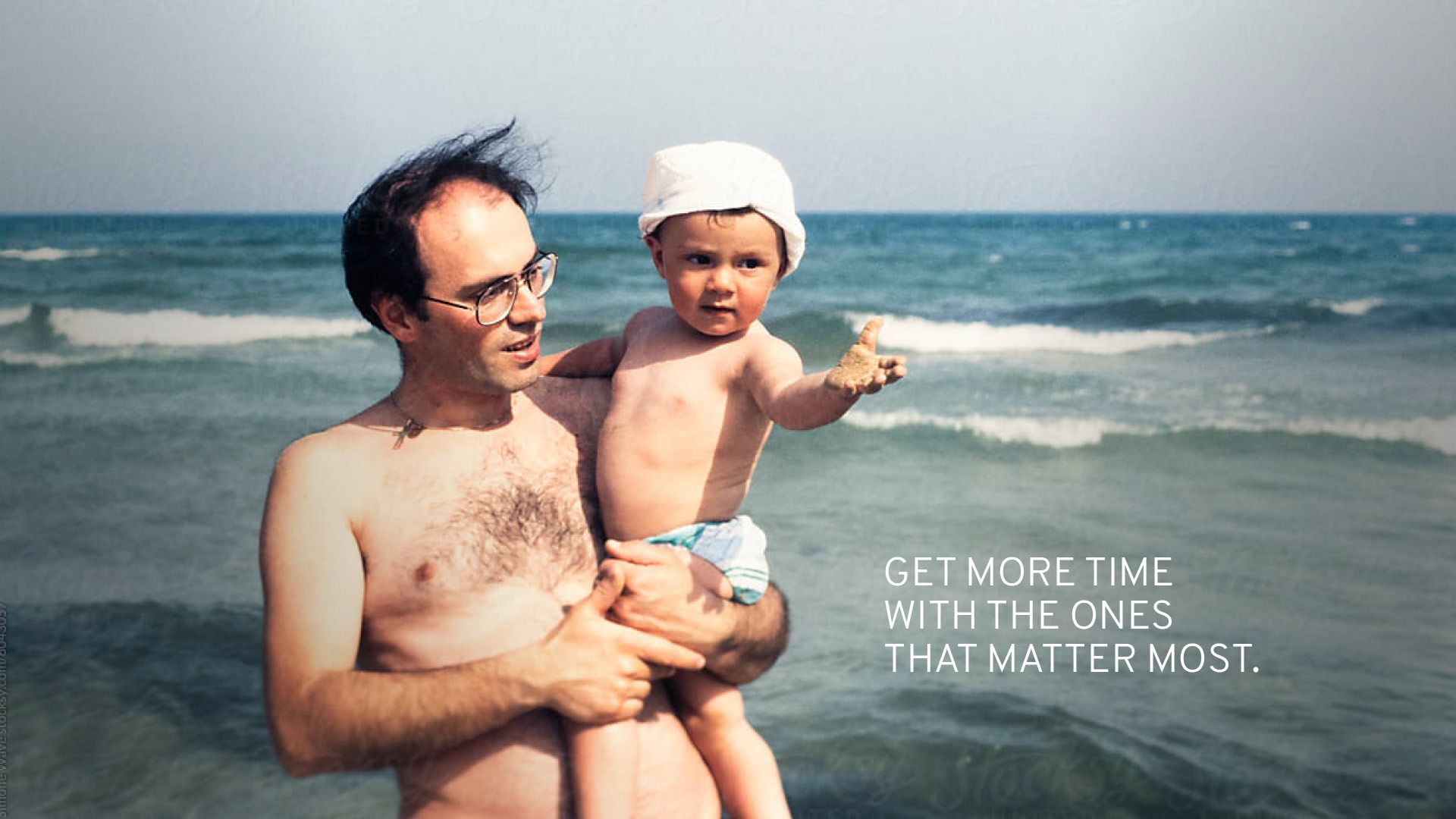 Photo of a father at a beach with an infant.