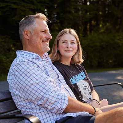 Photo of a father lovingly smiling at his teenage daughter.