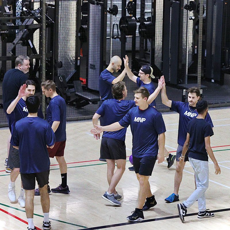 Photo of team in blue AMP-branded activewear, high-fiving enthusiastically after completing a 45-storey stair climb.