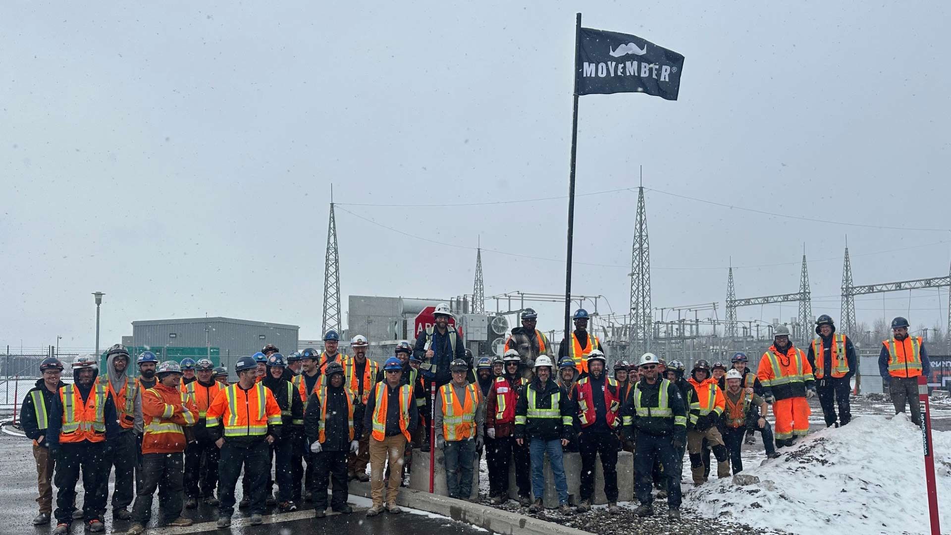 Photo of Movember supporters at an outdoor industrial work site.