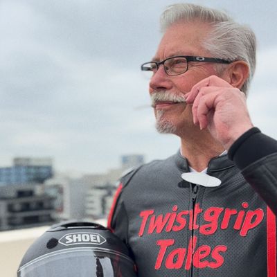 Photo of Movember supporter, Bruce Whalley, twirling his grey moustache.