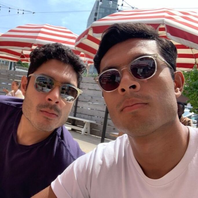 Portrait photo of two men in cool-looking sunglasses, looking to camera.