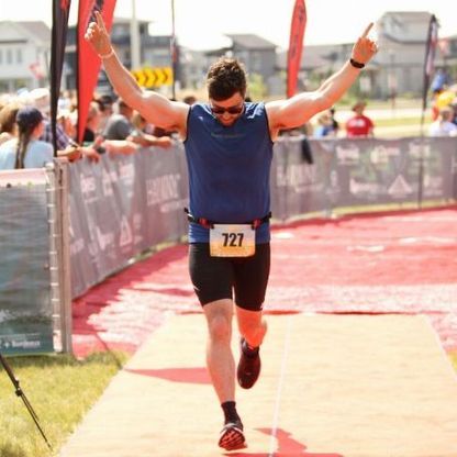 Photo of marathon runner gesticulating triumphantly to camera.