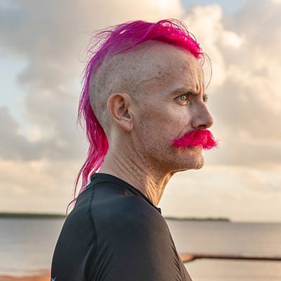 A side-viiew photo of Movember supporter Ben Anderson, sporting pink hair and a glorious pink moustache.