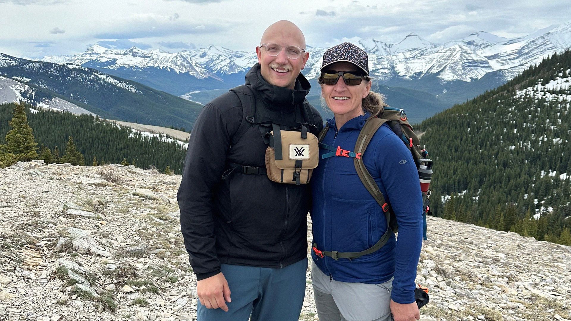 A mother and son pose on a mountain hike