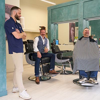 Photo of smiling men in a barber shop.