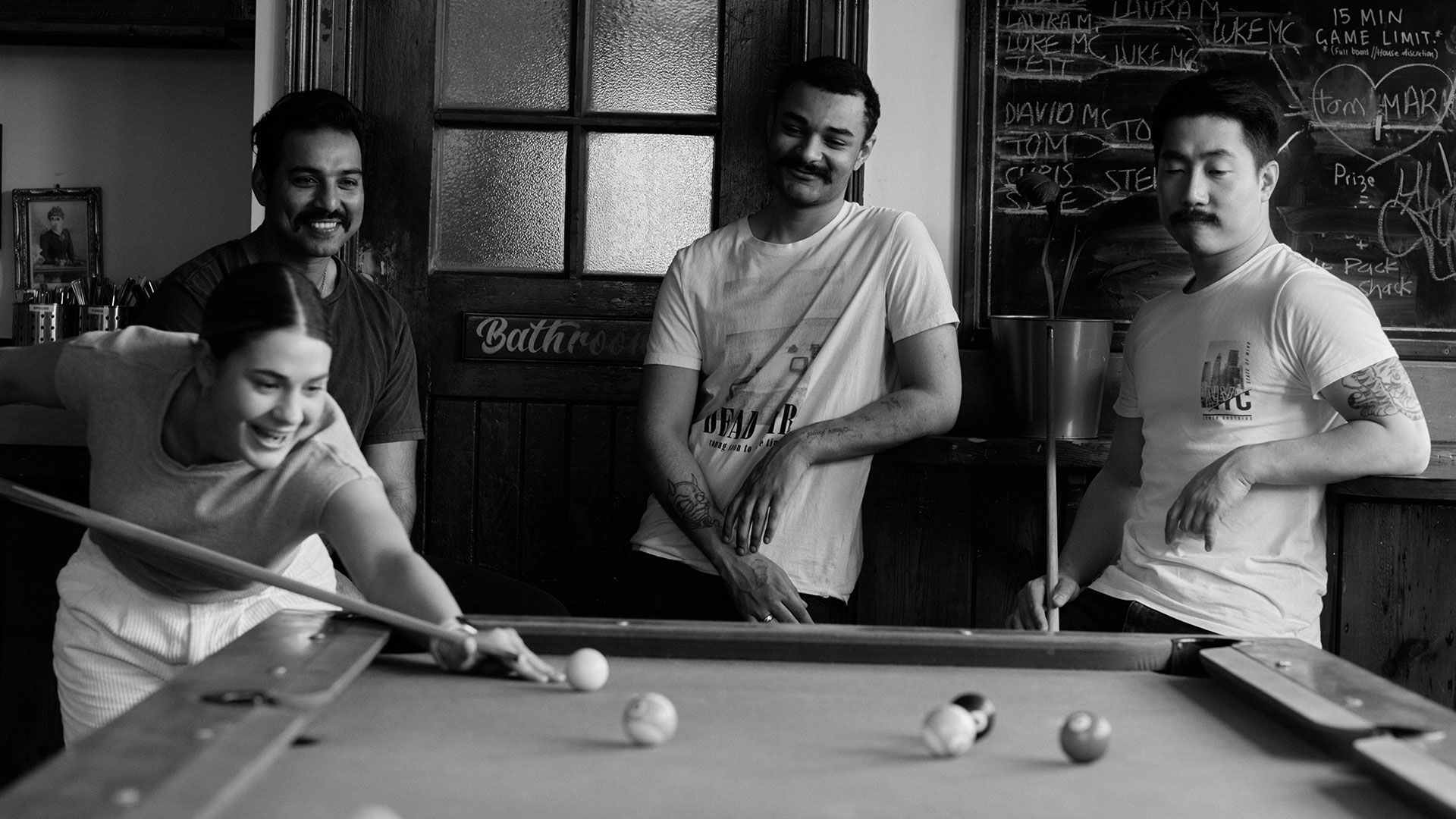 A group of friends playing pool in a pub.