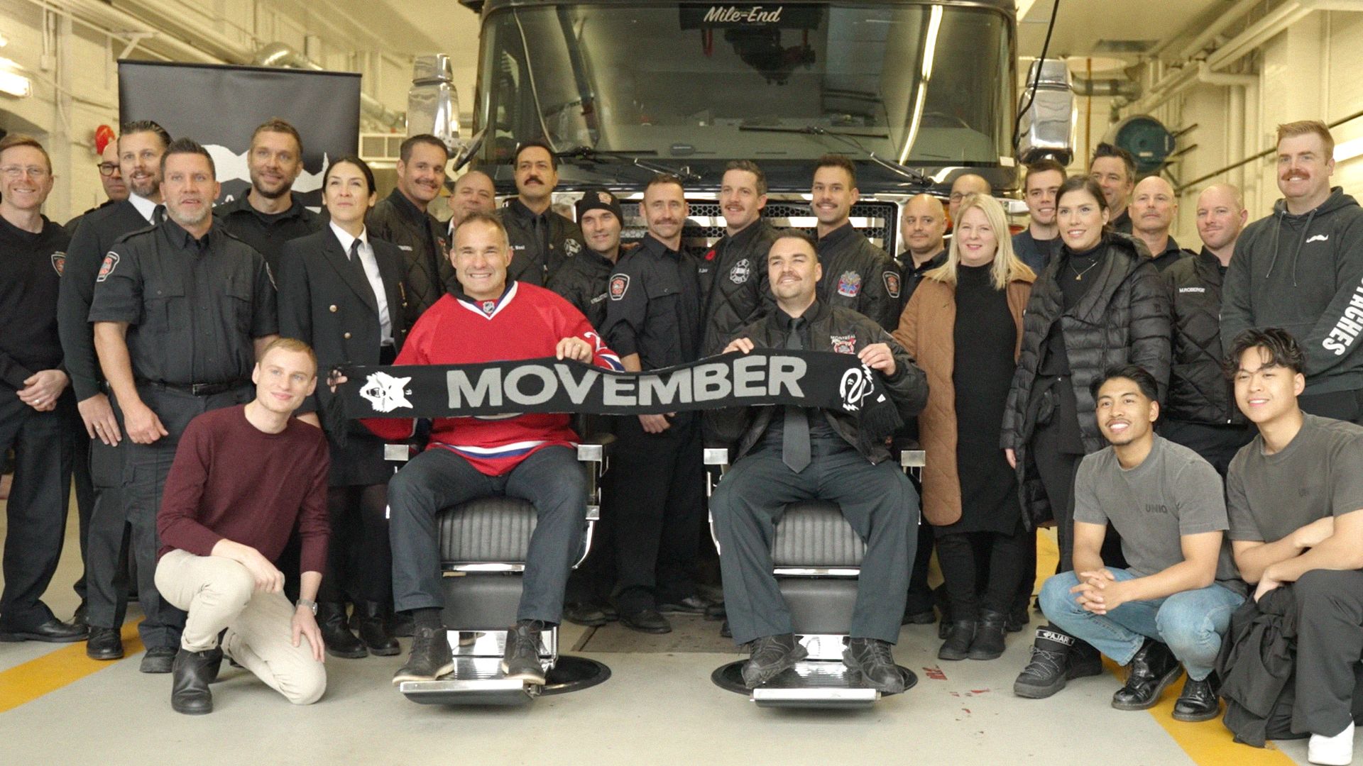 A group of Movember fundraisers pose in a fire hall